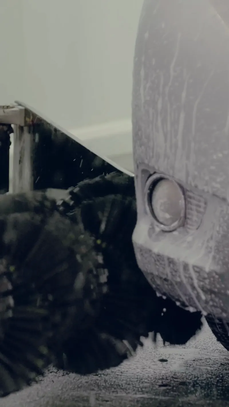 Foam brushes working around a car's front bumper
