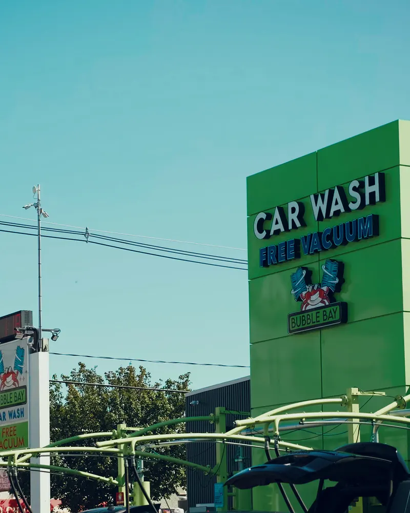 The green Brockton building sign, reading Car Wash and Free Vacuum, above the vacuum bays