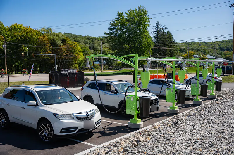 Cars parked under the green arches of the free vacuum bays